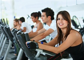 Group of gym people exercising on cardio machines